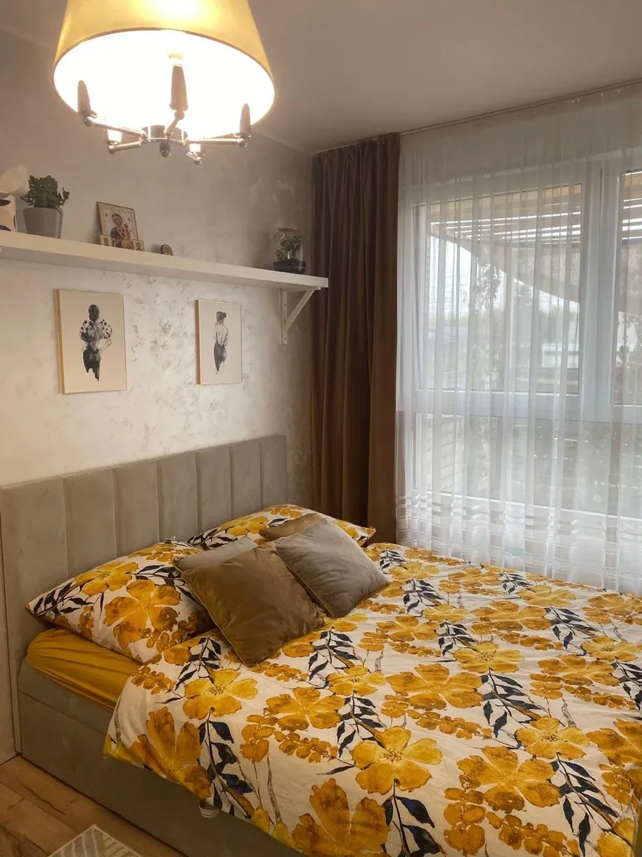 Sypialnia z tapicerowanym zagłówkiem i półką nad łóżkiem